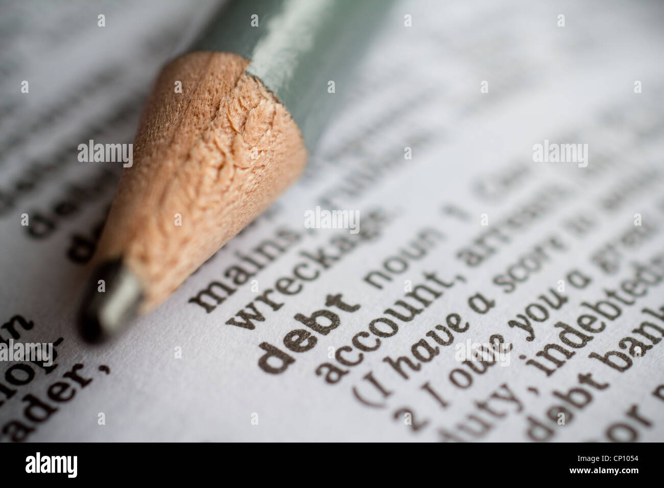 The word "debt" shown in a dictionary with a pencil, symbolising financial obligation or economic burden. Stock Photo