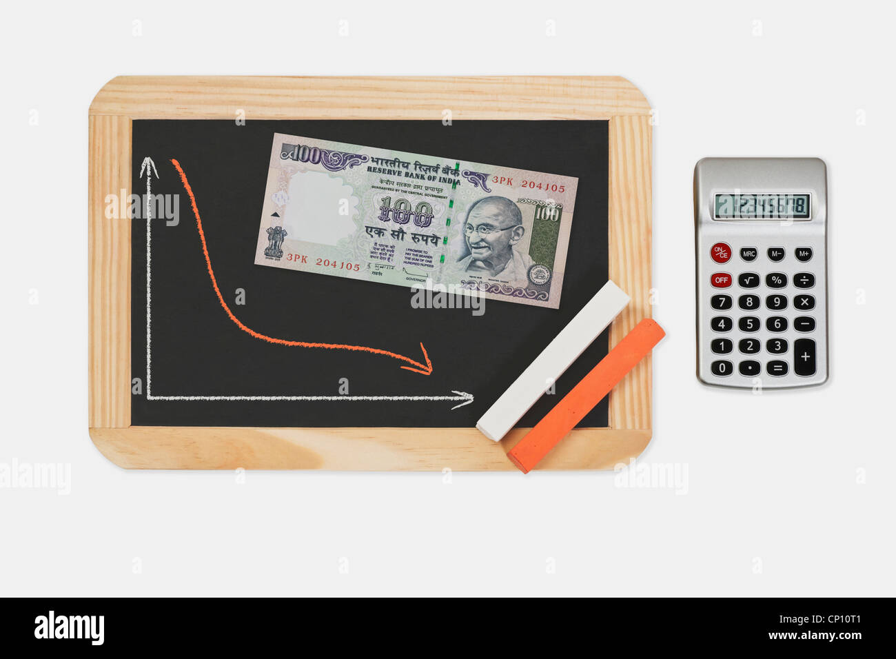 Chalkboard, chart with an declined curve. On the chalkboard lies a Indian 100 rupee bill with the portrait of Mahatma Gandhi. Stock Photo