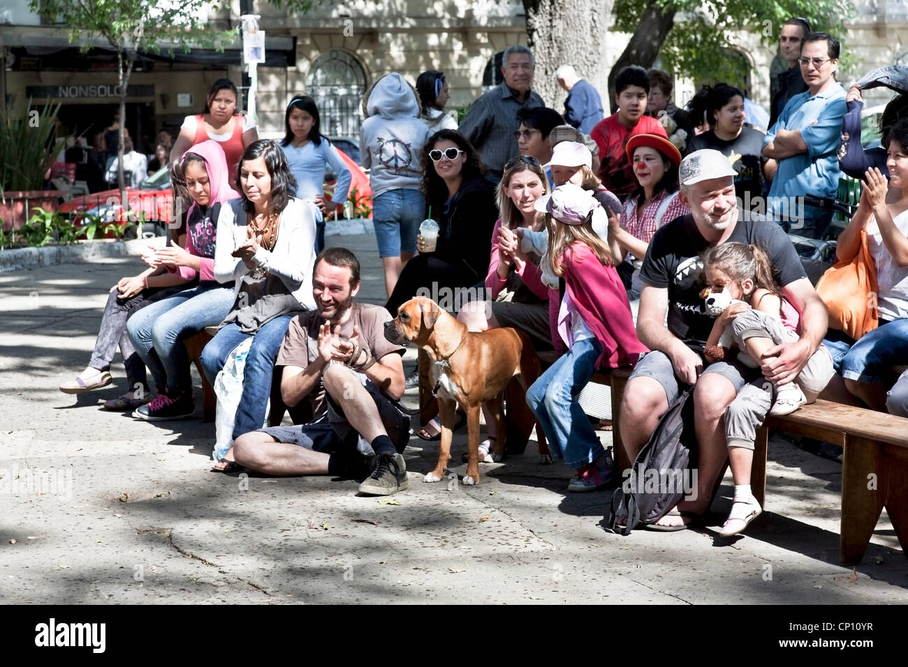 crowd of Mexican adults & children & one American family react to a