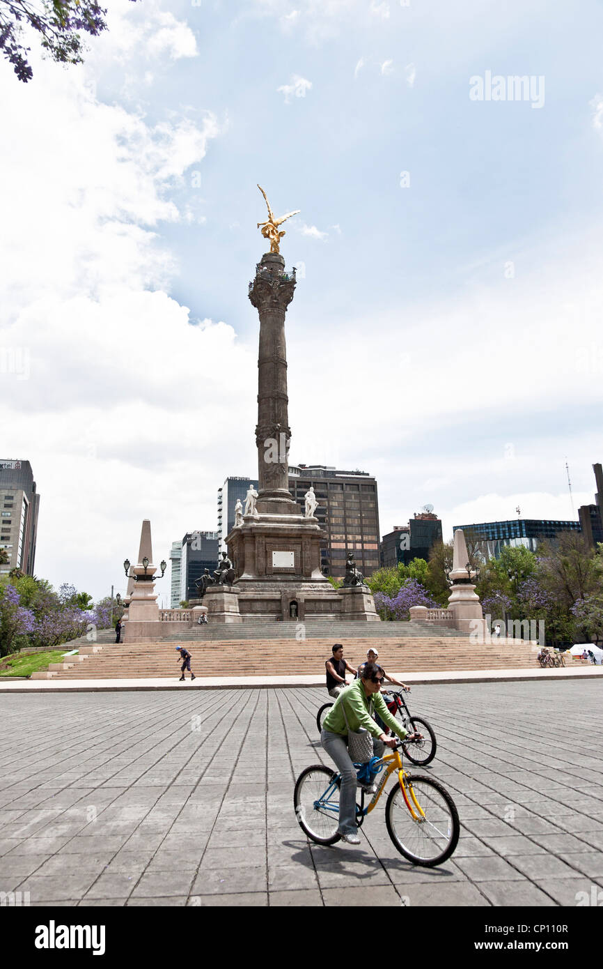single & tandem bicyclists share traffic free glorieta below Angel monument on a glorious spring Sunday Paseo de la Reforma Stock Photo