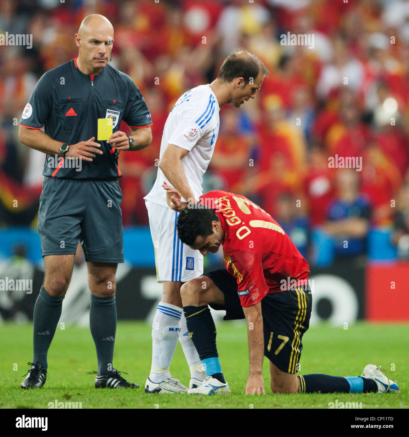 Referee Howard Webb (L) books Angelos Basinas of Greece after Basinas fouled Daniel Guiza of Spain during a Euro 2008 match. Stock Photo
