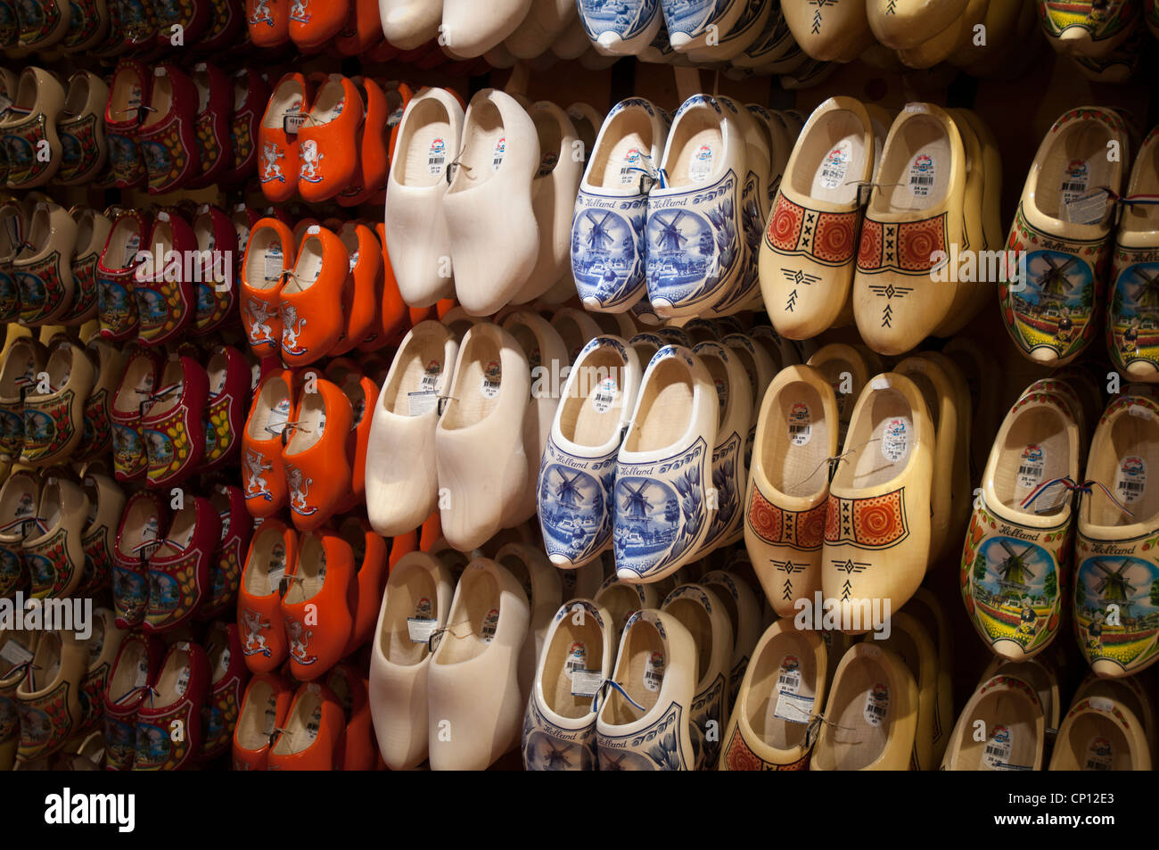 Big choice of wooden shoes Dutch souvenirs hanging on wall in shop Stock Photo