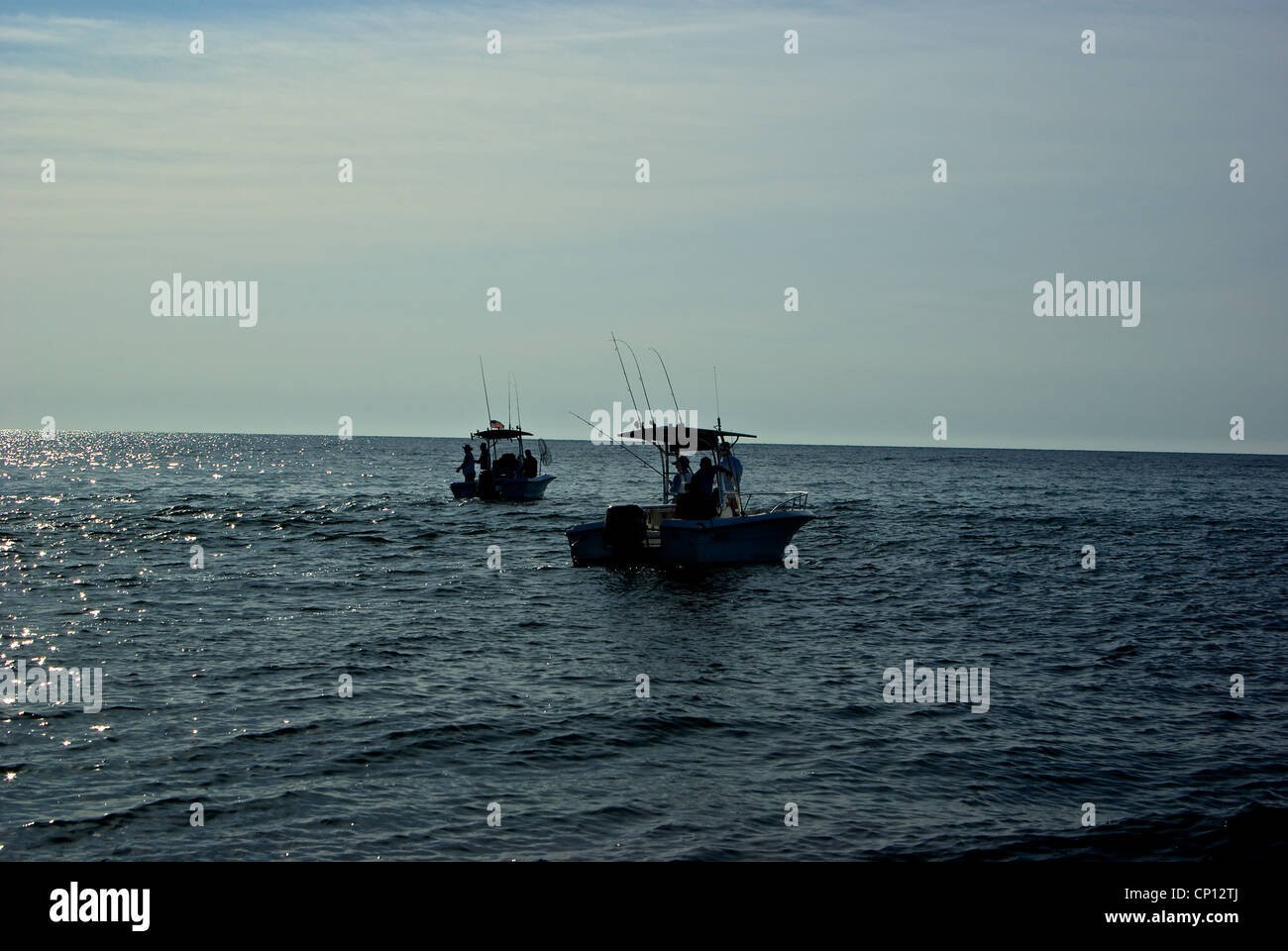 Center console sport fishing boats in silhouette shallow inshore saltwater anchor angling Gulf Mexico Alabama coast Stock Photo