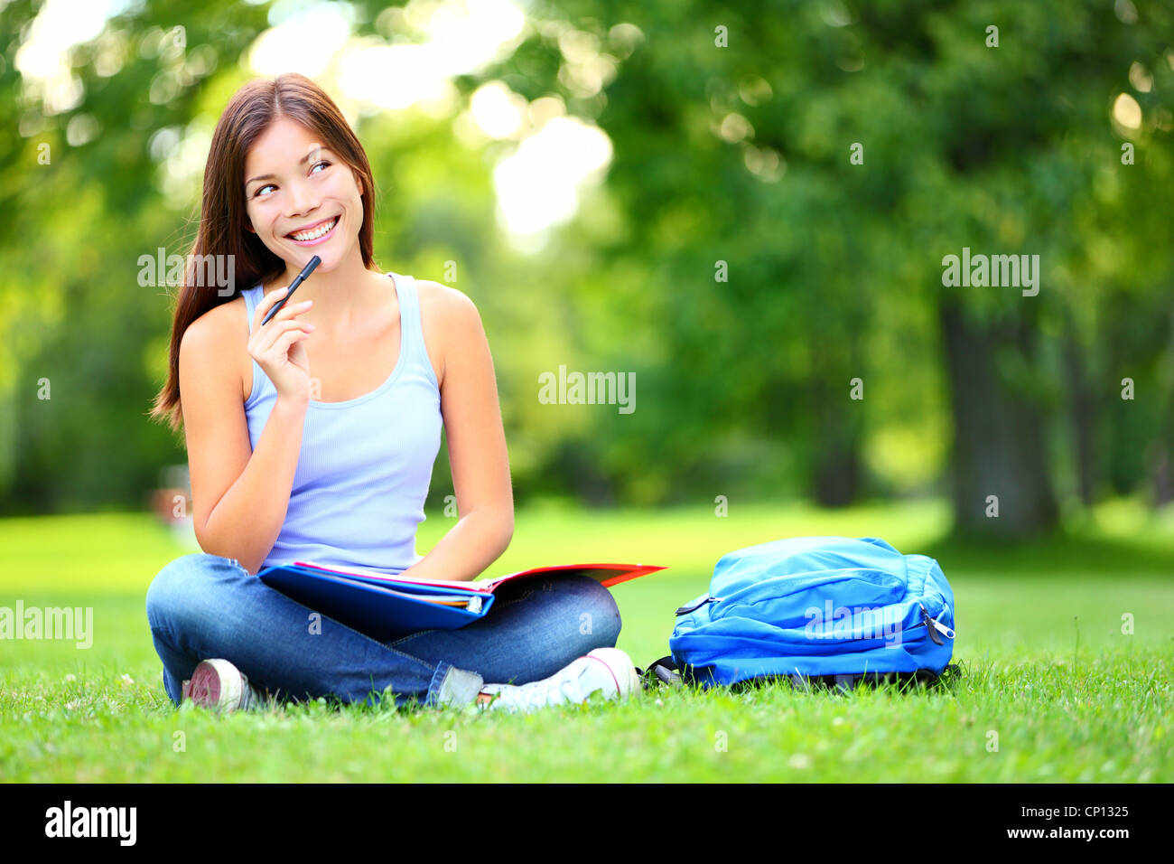 Thoughtful young mixed race Chinese Asian / Caucasian female student looking away at copyspace sitting in university campus Stock Photo