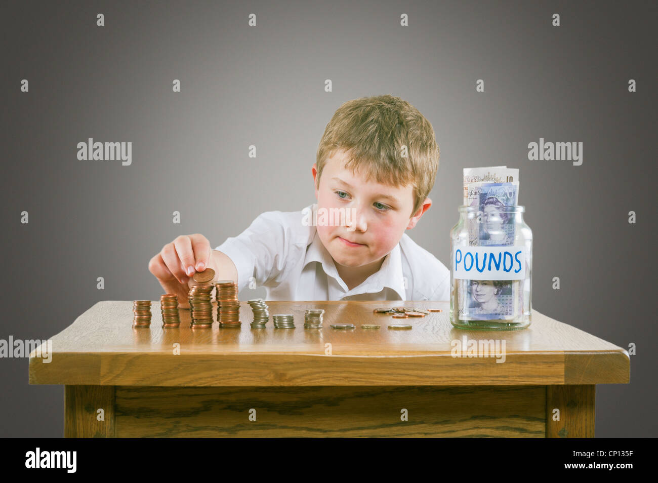 An 8 year old boy counting money Stock Photo
