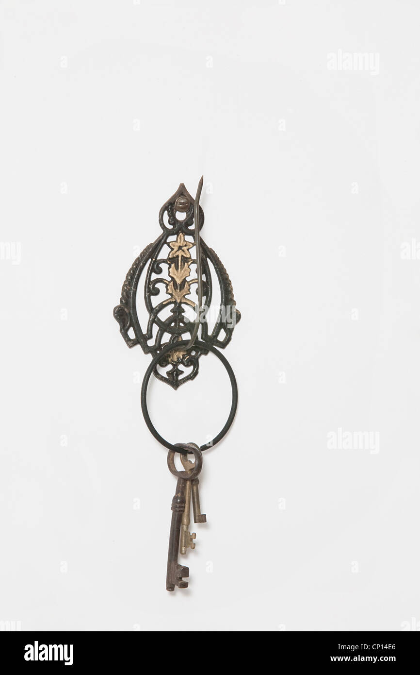 Antique key holder with three skeleton keys on a black ring. White background. Stock Photo