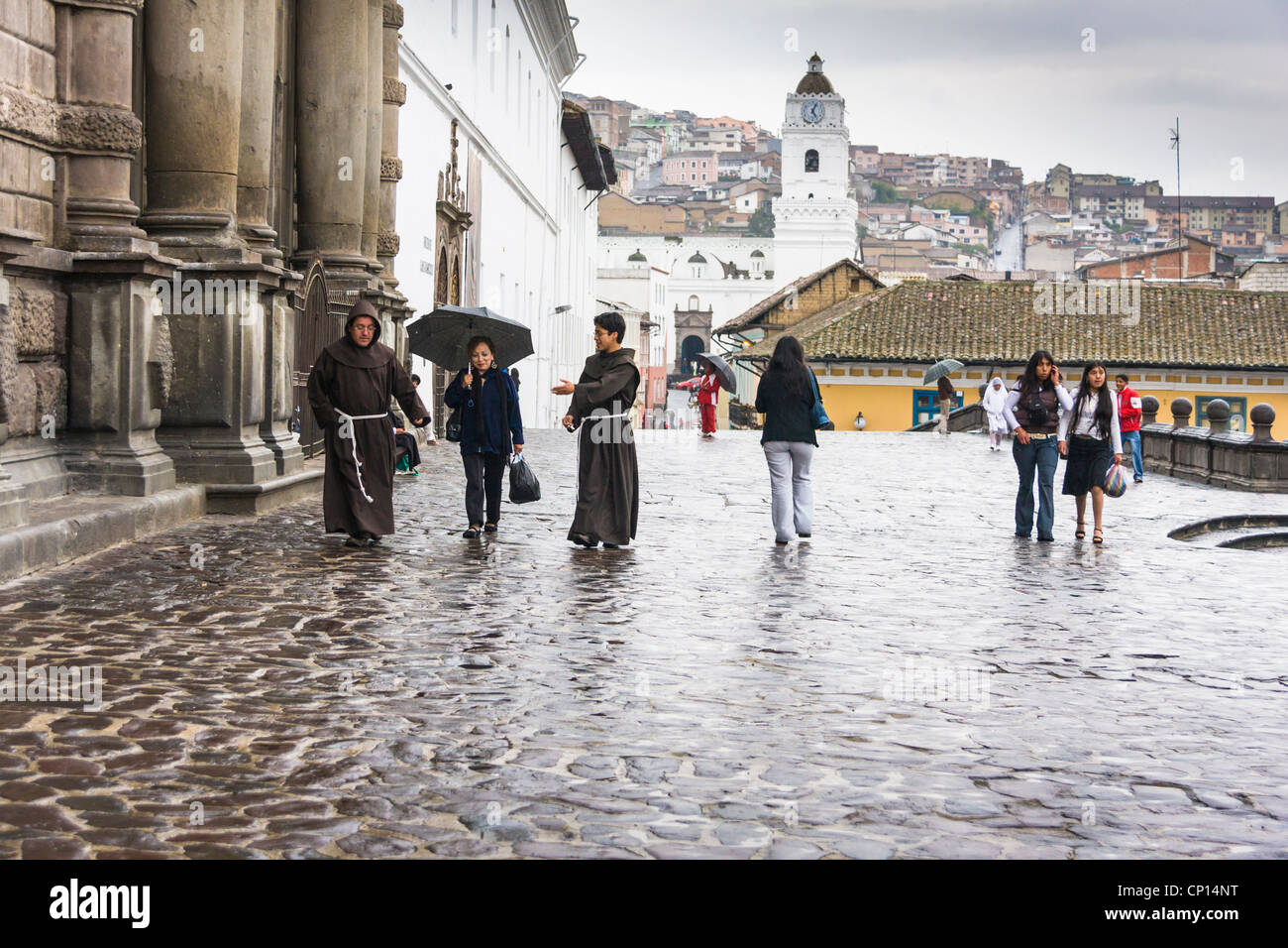 Franciscan friars at 'San Francisco Square' or 'Plaza San Francisco' in Old Town, Quito, Ecuador - walking in the rain. Stock Photo
