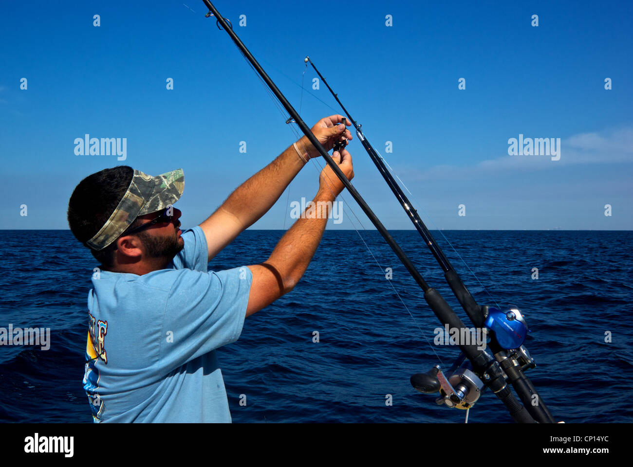 Deckhand attaching sliding release clip to kite line fishing live