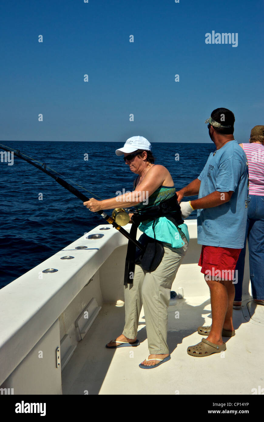 Woman using fighting belt to hold fishing rod playing big deepsea