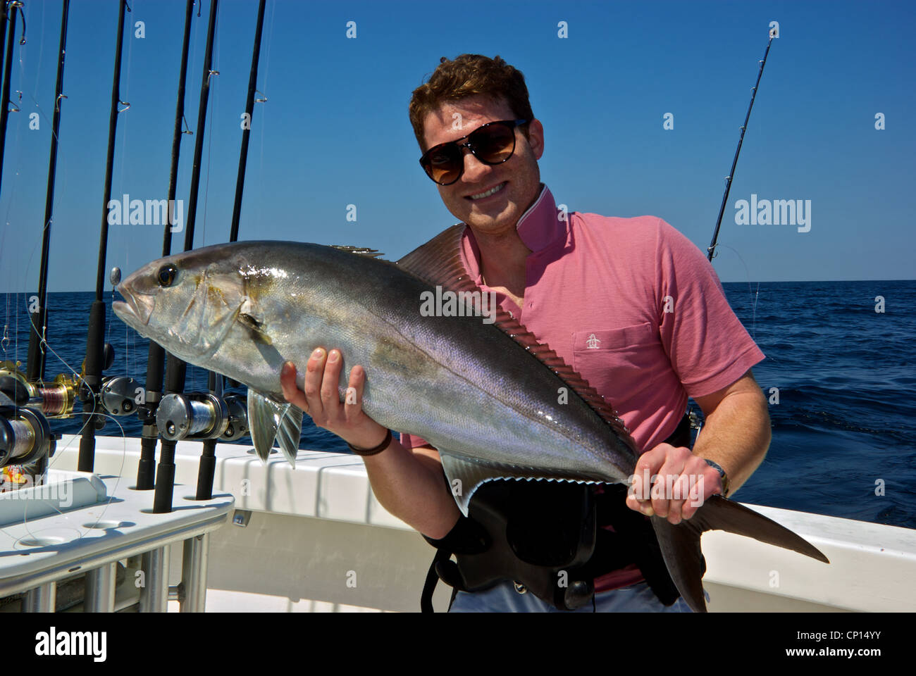 Young male angler holding big greater amberjack deepsea gamefish Gulf Mexico offshore fishing Alabama Coast Stock Photo