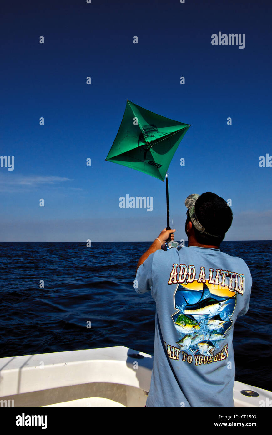 Deckhand readying small kite on short rod for fishing live bait rig just  below surface deepsea Gulf Mexico offshore angling Stock Photo - Alamy
