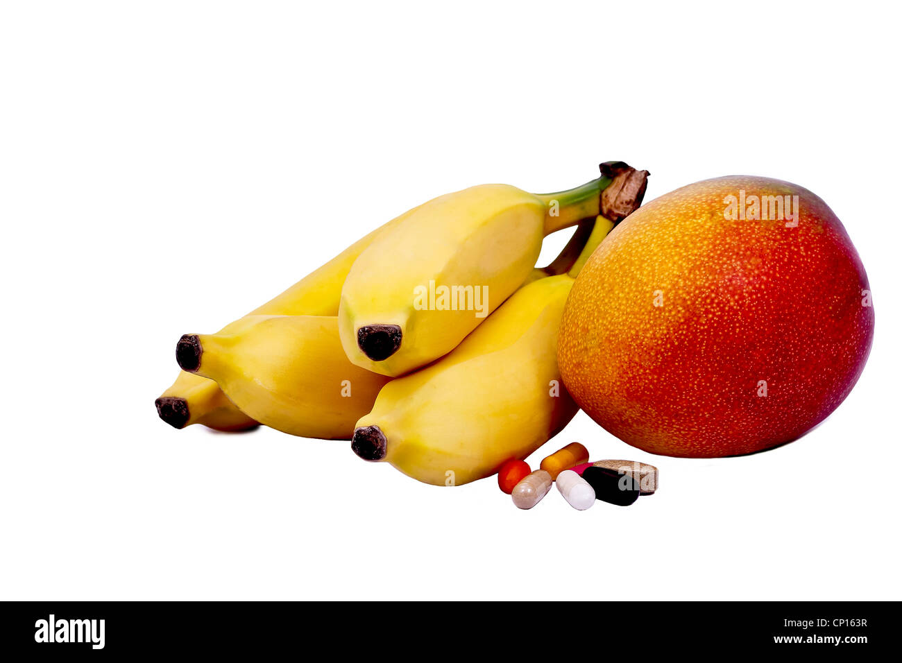 a bunch of bananas and one mango with vitamin and mineral tablets and