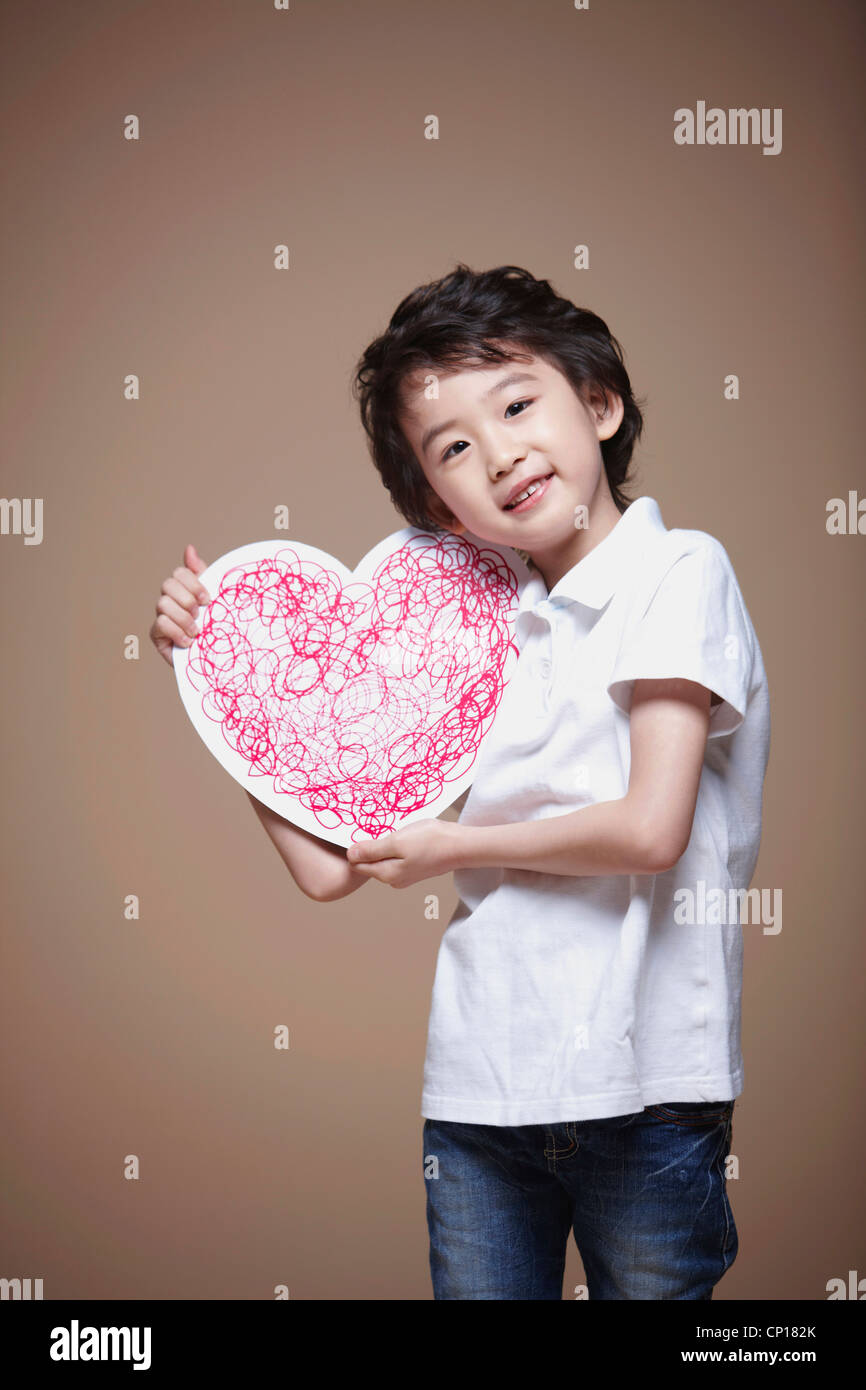 A boy holding red heart Stock Photo - Alamy
