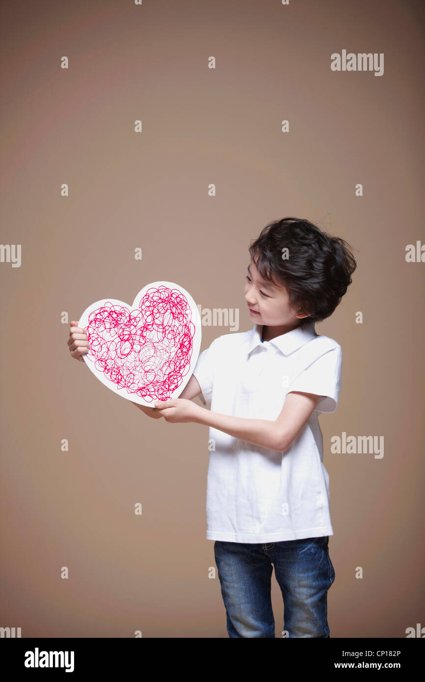 A boy holding red heart Stock Photo - Alamy