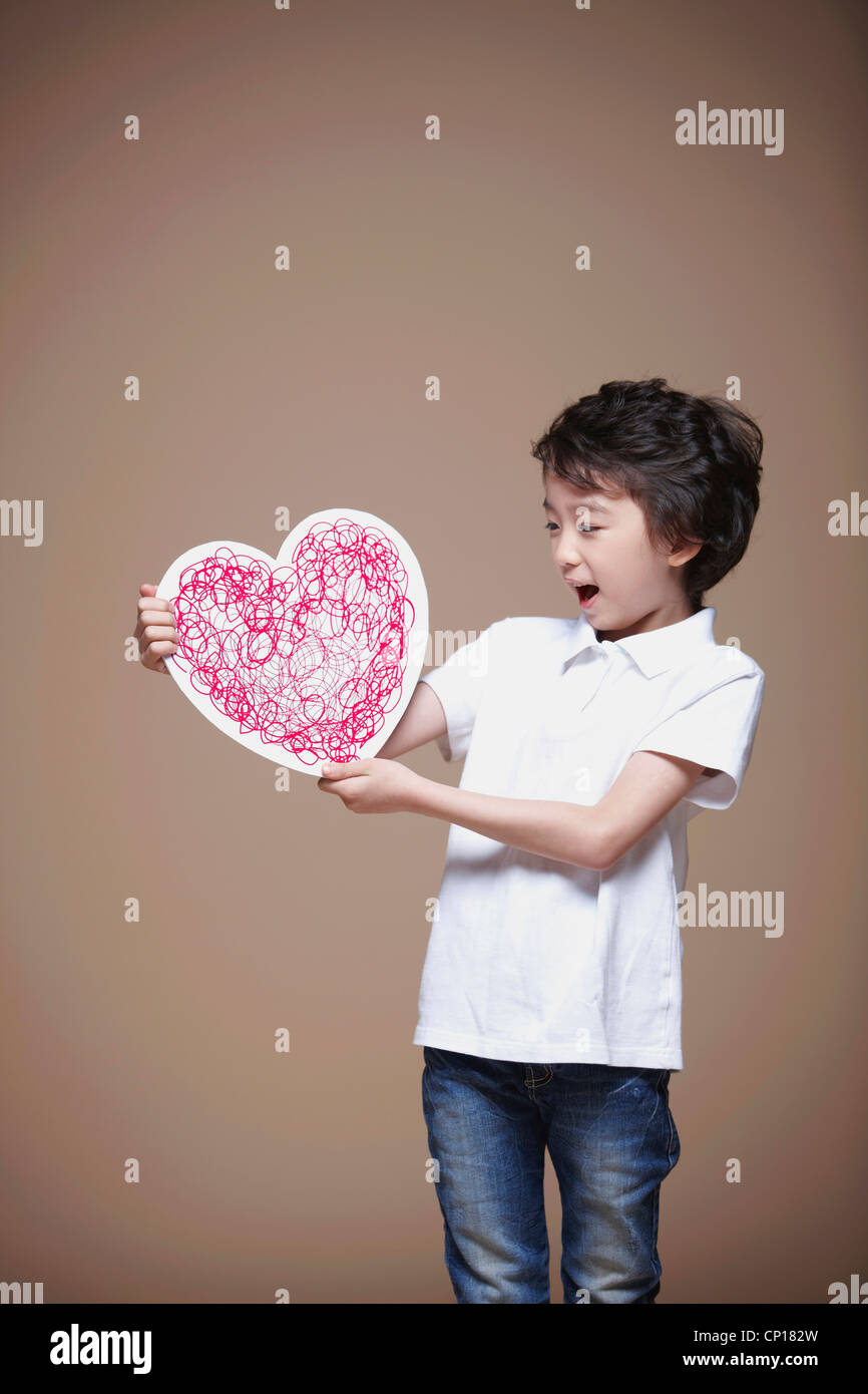 A boy holding red heart Stock Photo - Alamy