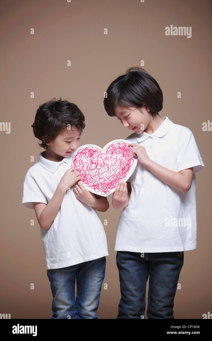 A boy and girl holding red heart Stock Photo - Alamy