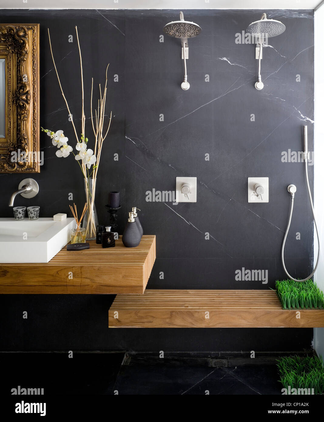 Bathroom with dark grey wall, ornate mirror in gilt frame, washbasin