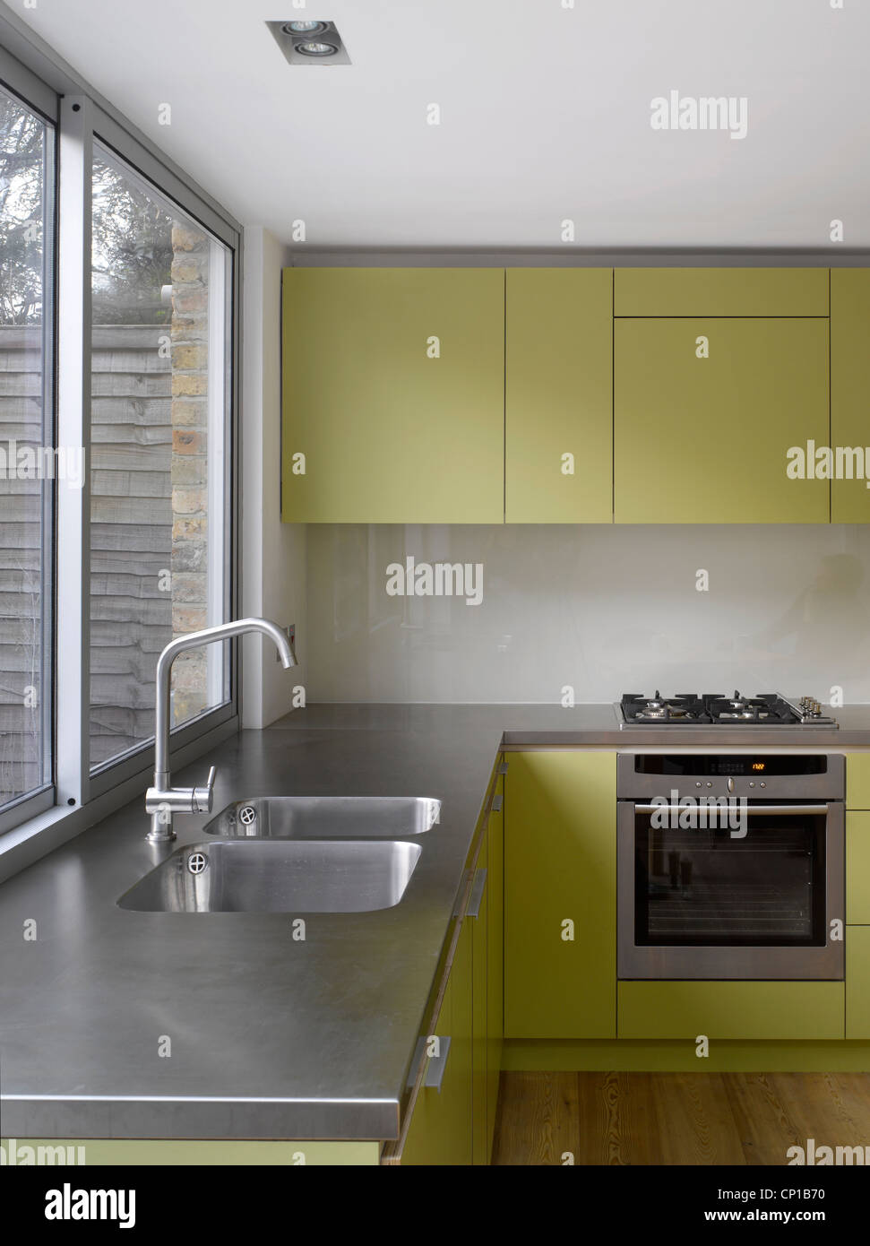 Stainless steel sink at uncurtained window of kitchen extension in Islington, London, UK. Paul Archer Design. Stock Photo