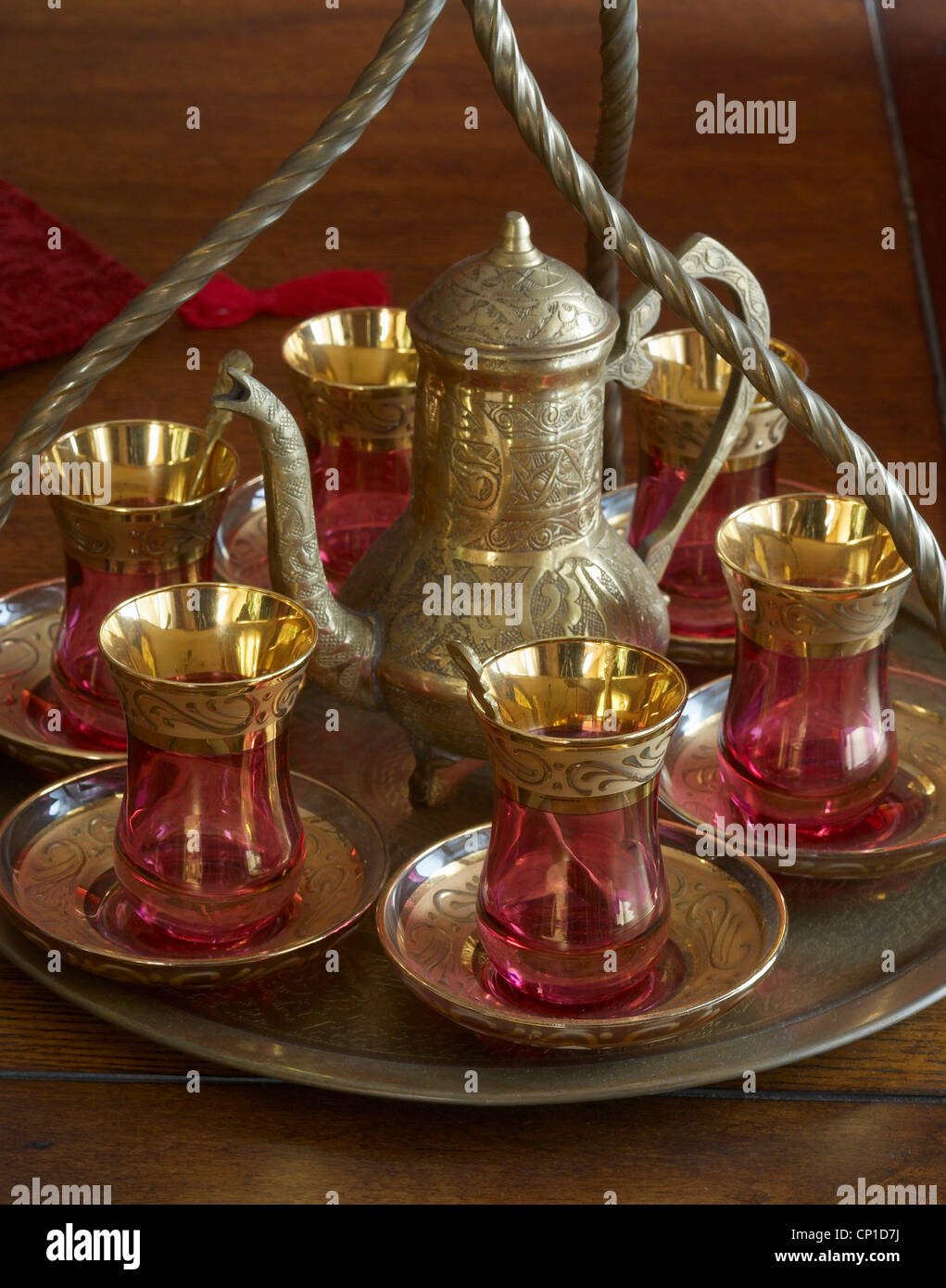 Turkish style red glass cups with brass tops and teapot on brass tray Stock Photo