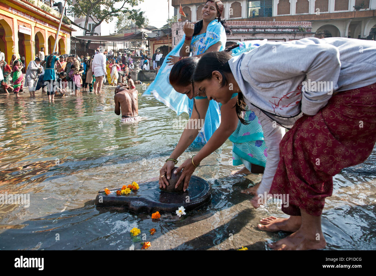 Indian women worshiping a Shiva lingam. Godavari river. Nasik. India Stock Photo
