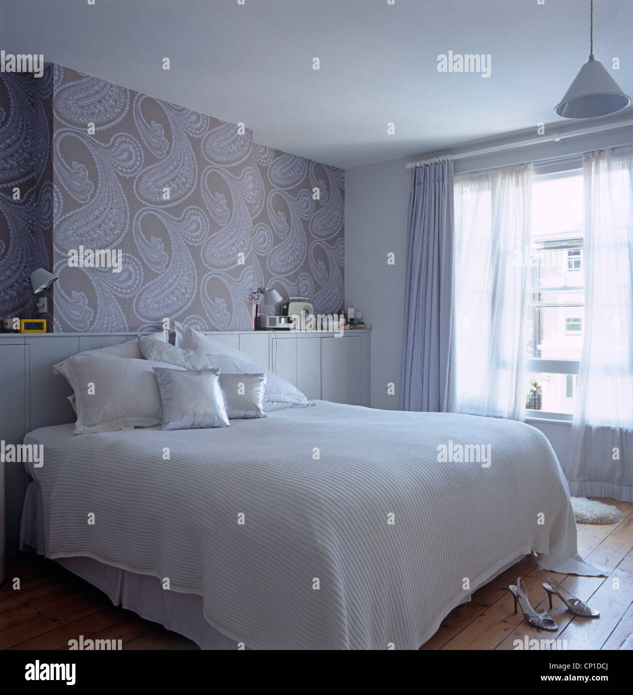 Double bed with built in storage as headboard in blue bedroom Stock