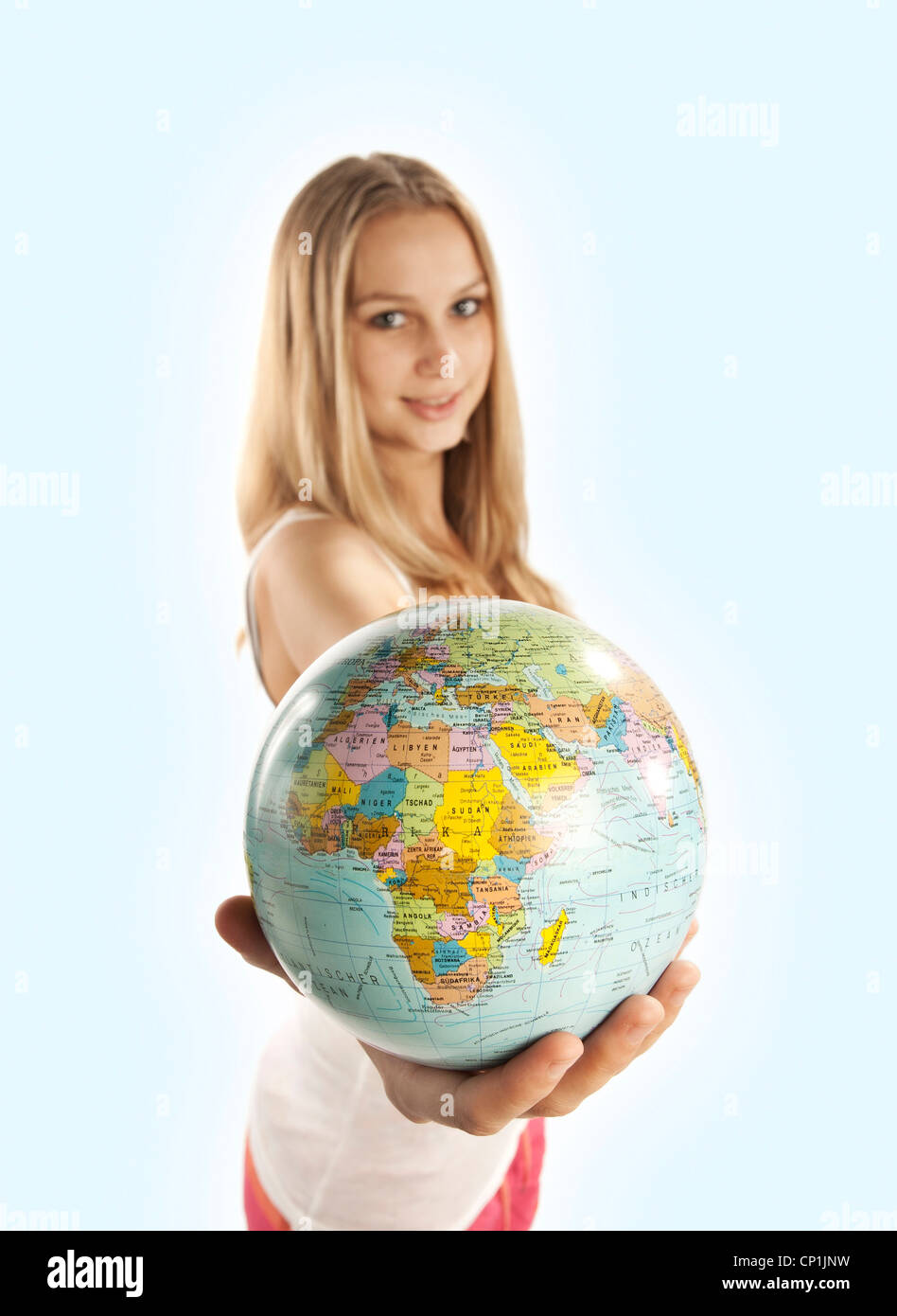 Young beautiful woman holding a globe in her hand. Stock Photo