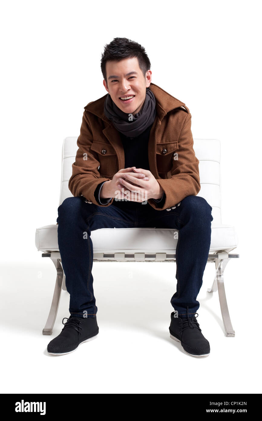 Stylish young man sitting on a chair Stock Photo - Alamy