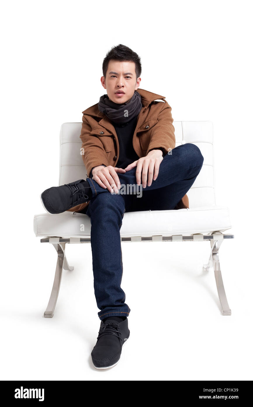 Stylish young man sitting on a chair Stock Photo - Alamy