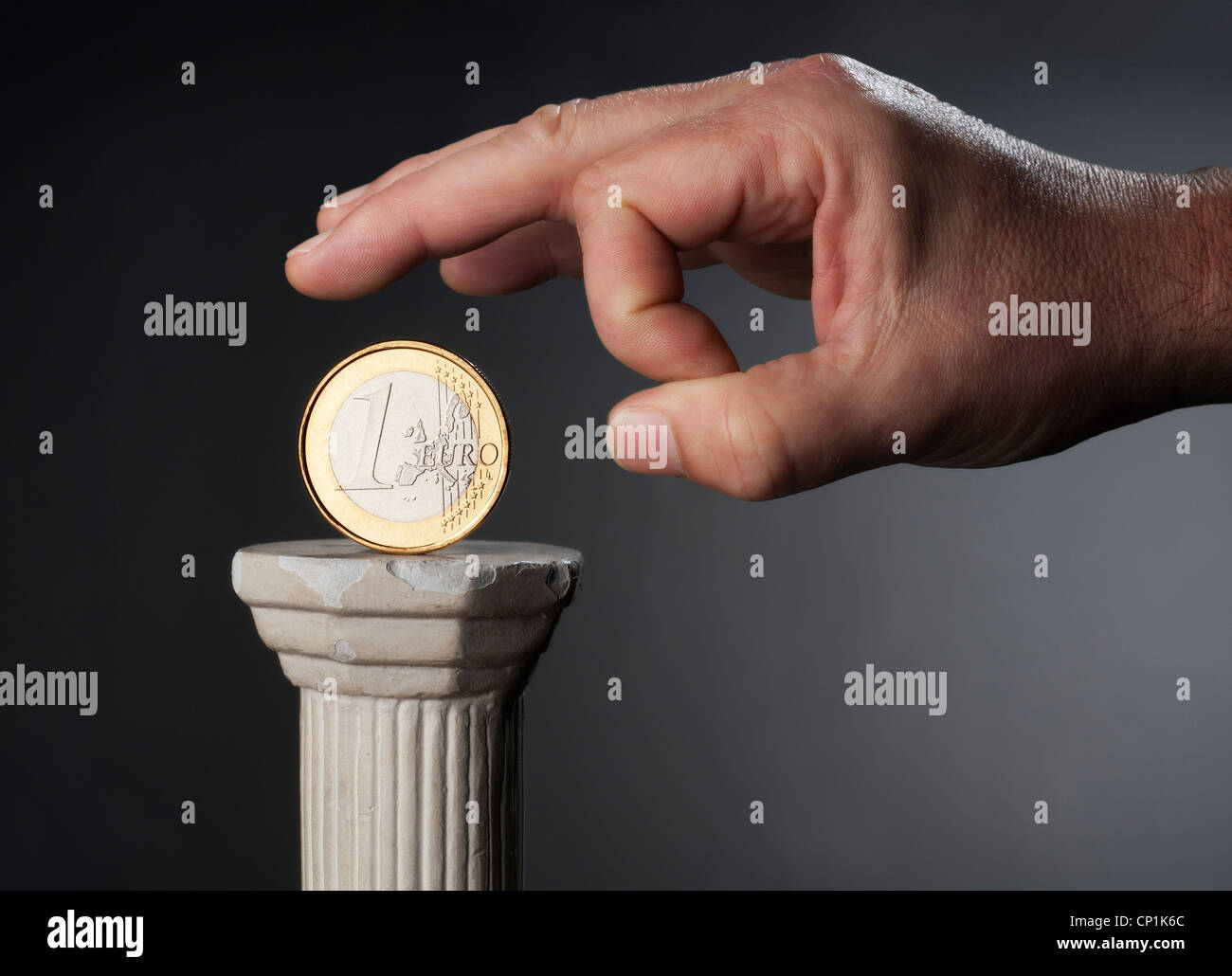 Closeup of a hand that attaches to snap a € coin from a stack. Stock Photo