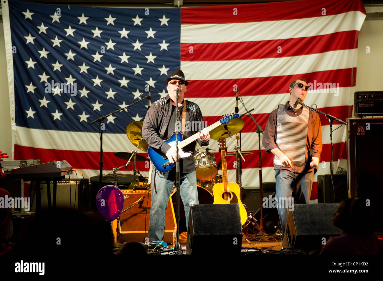 Band playing on stage with American flag in the background Stock Photo