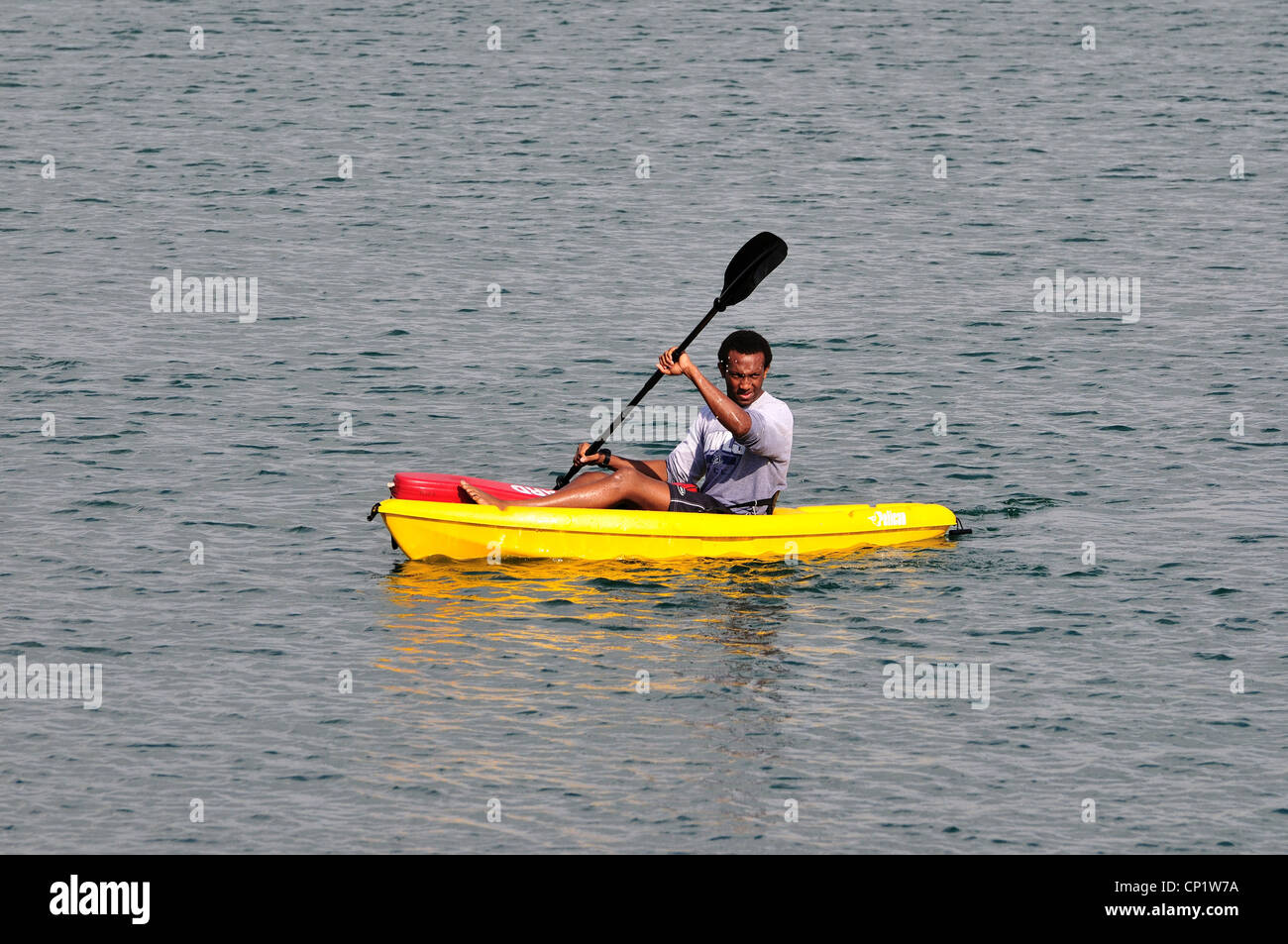 A young man paddles across a lake on a kayak Stock Photo - Alamy