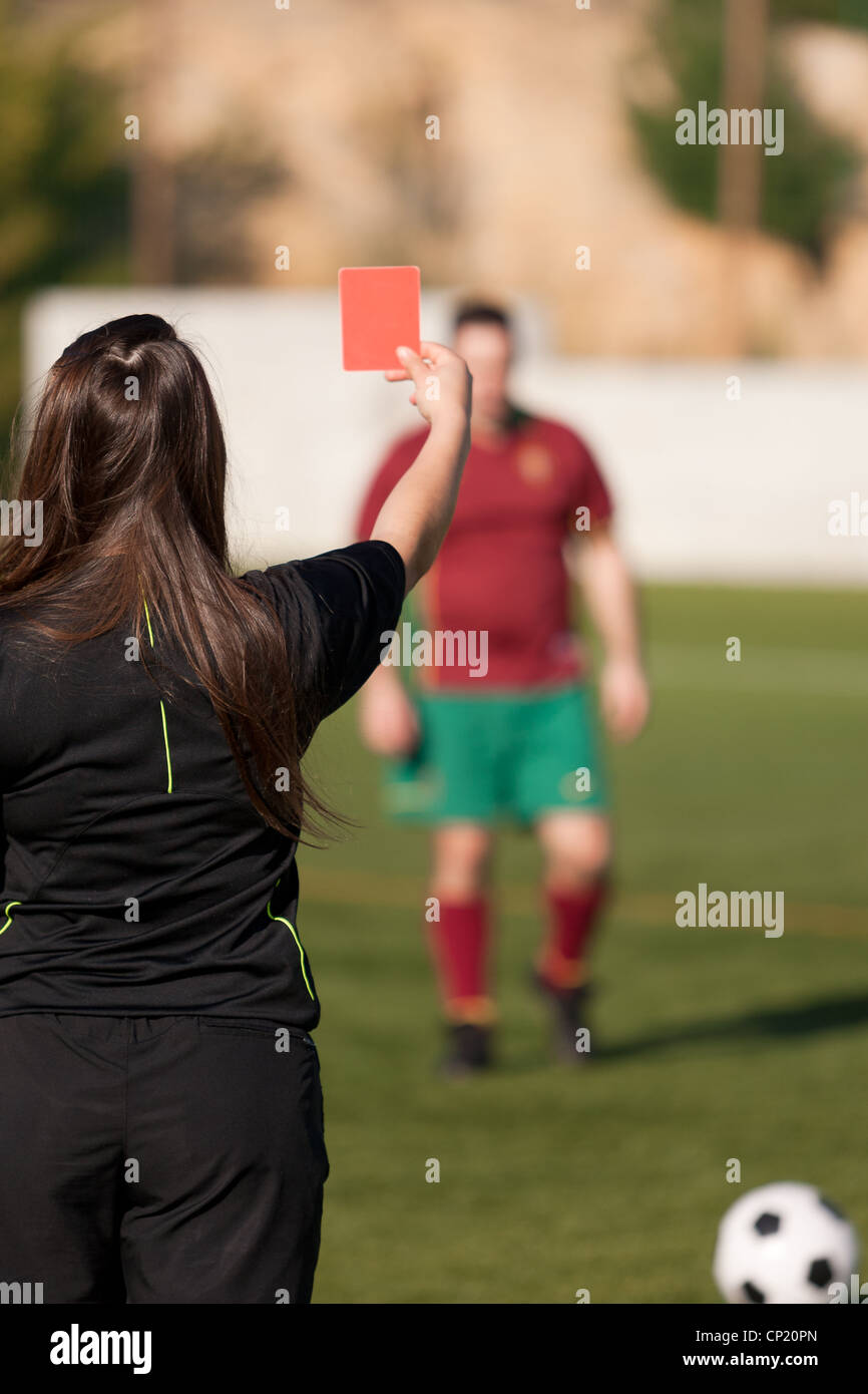 female referee showing the red card to the player Stock Photo