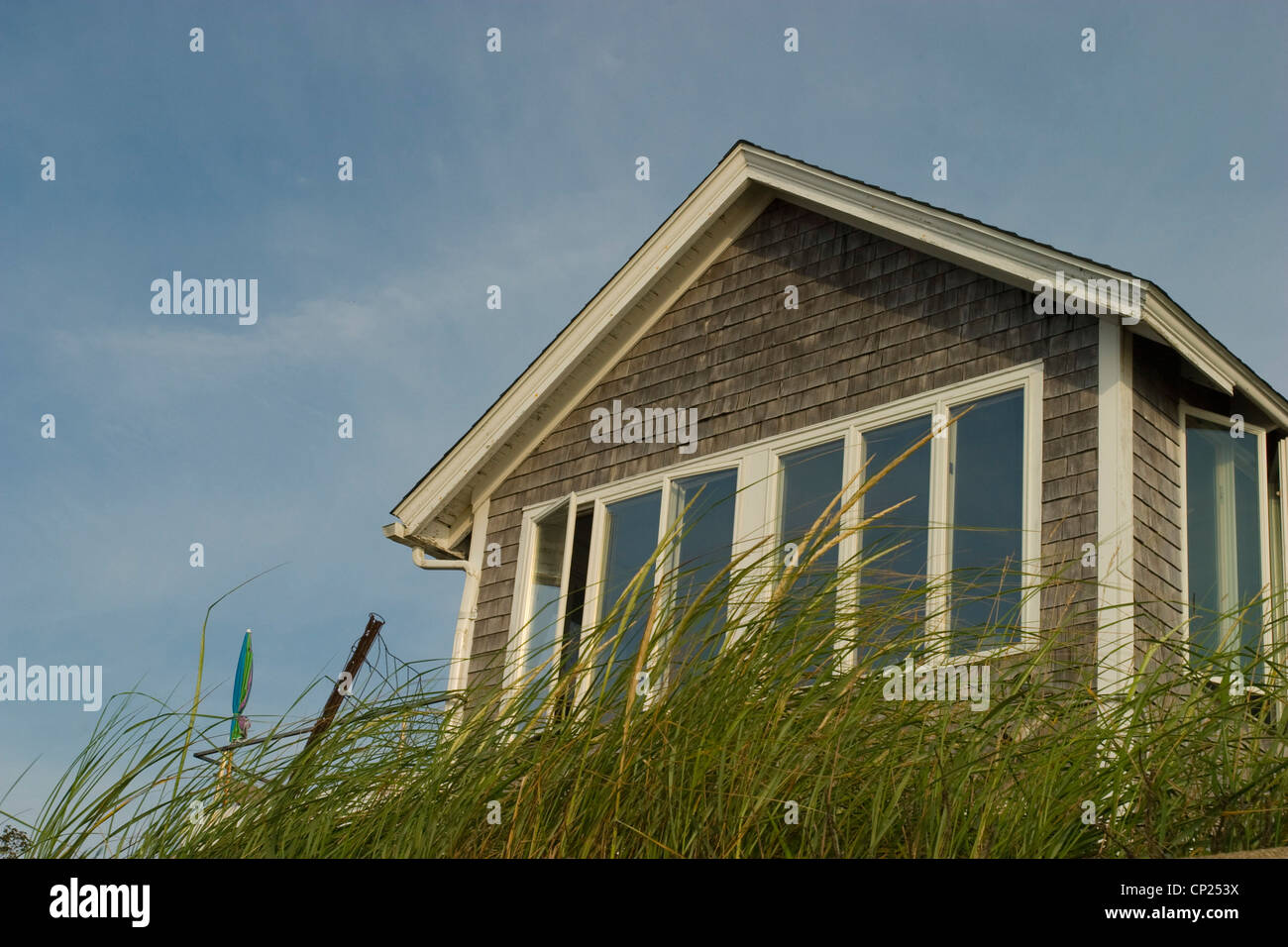 A Summer Cottage With Plenty Of Windows To View The Beach Grass