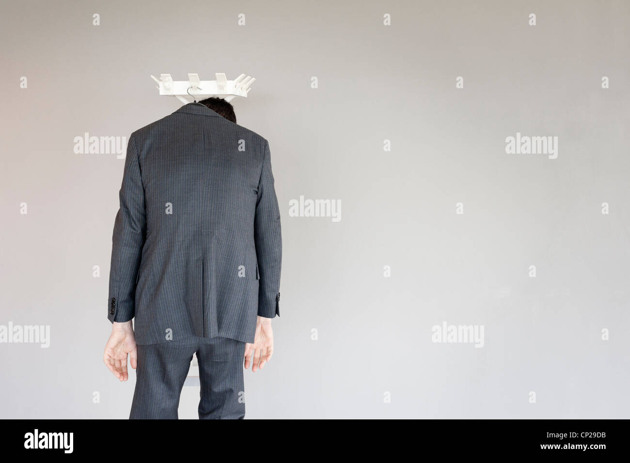 Unemployed business man left behind on a coat hanger (model released) Stock Photo