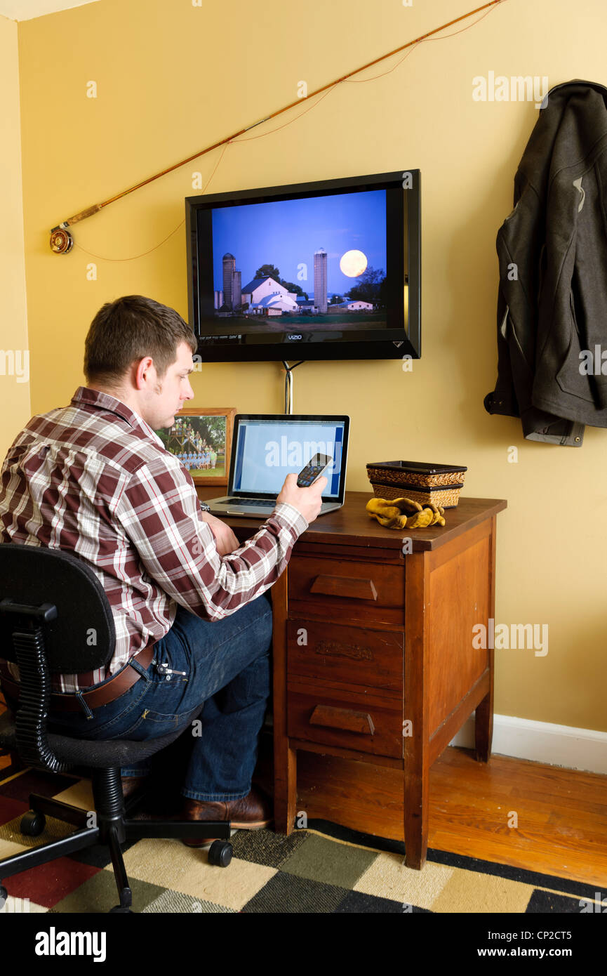 FARMER IN HOME OFFICE USING LAPTOP COMPUTER; WORKING FROM HOME Stock