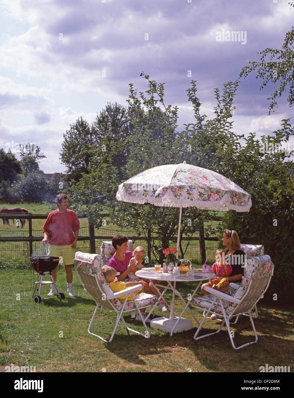 Family barbecue in garden, Winkfield, Berkshire, England, United Kingdom Stock Photo