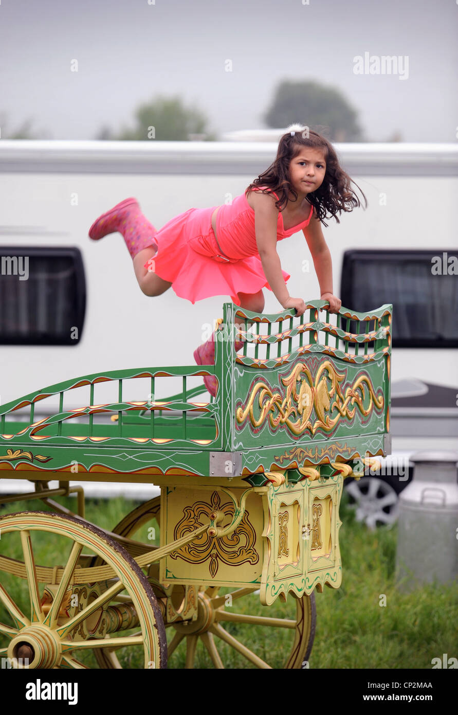 A girl stands upon a decorative trailer at the Stow-on-the-Wold horse fair May 2009 UK Stock Photo
