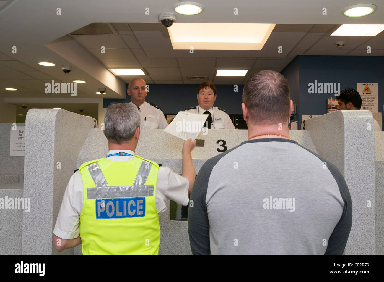 Suspect at charge desk in a police station Stock Photo