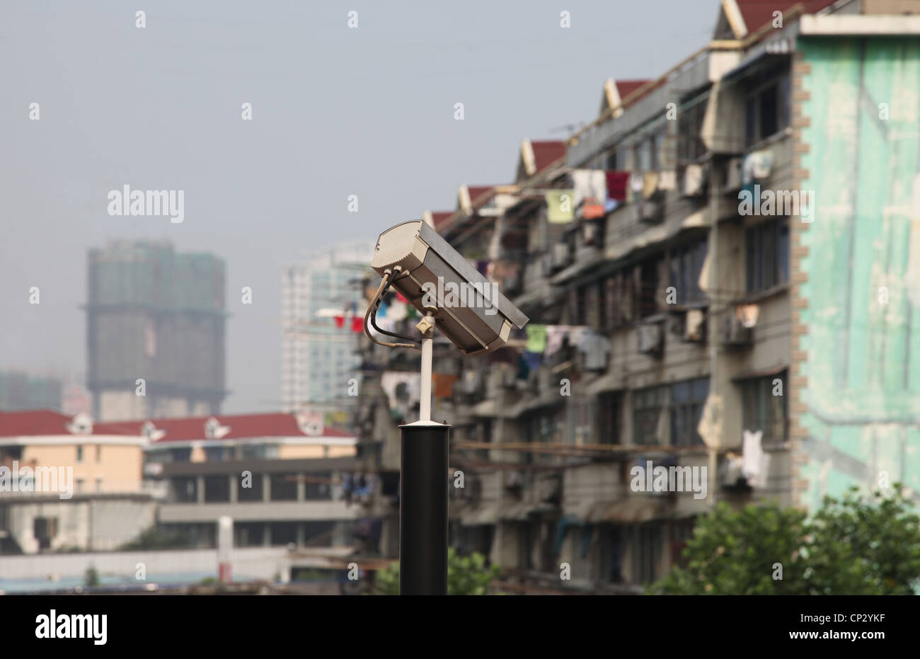 It's a photo of buildings in Shanghai in China. It's a street or a square in a big city. We can see trees and it's polluted. bad Stock Photo