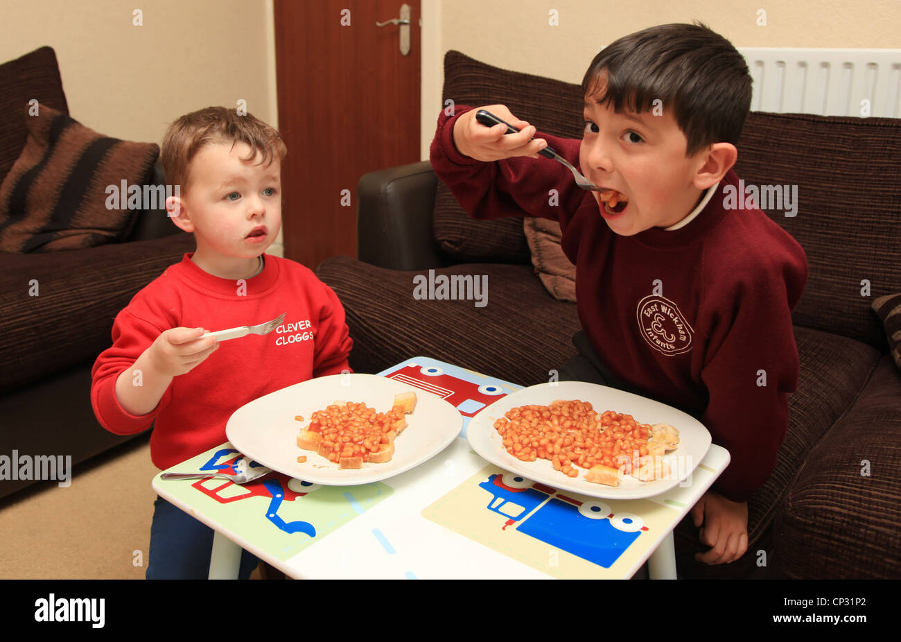 2 brothers eating dinner at a small table in the lounge after school