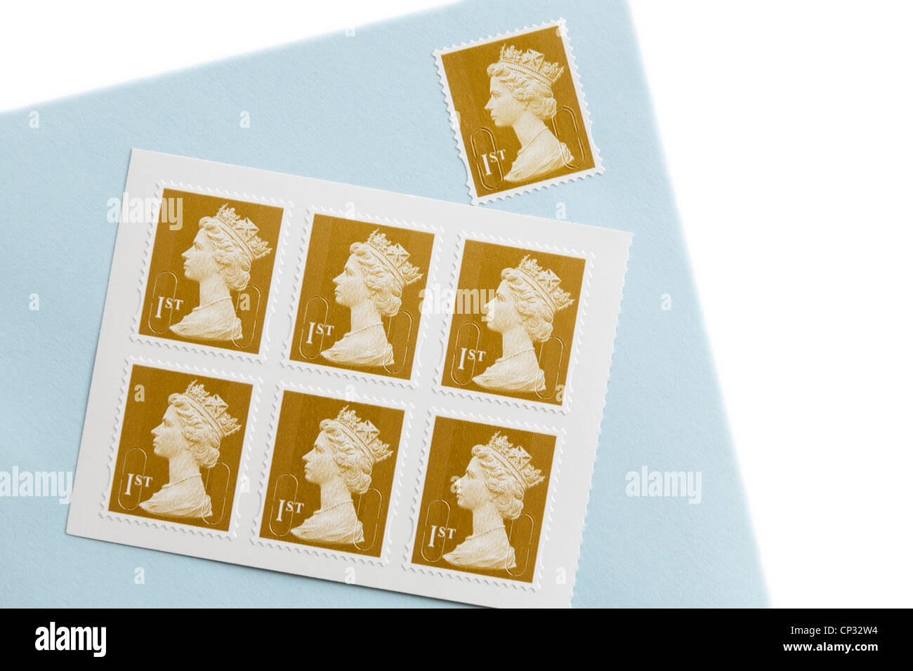 Royal Mail first class postage stamps and an envelope with a stamp on a white. England, UK, Britain. Stock Photo