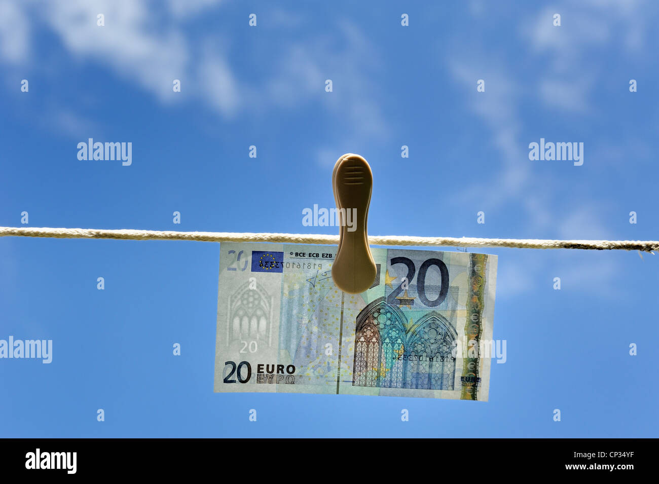 Euro note on a washing line with blue sky and clouds in the background england uk Stock Photo