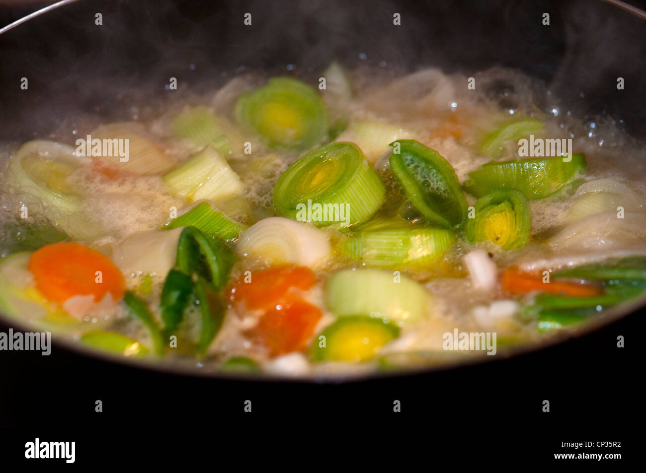 Diced vegetables simmering on hob Stock Photo