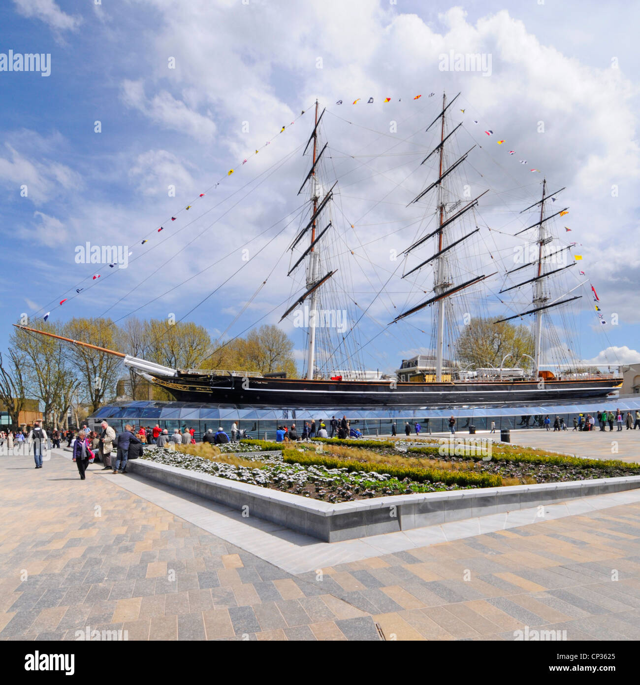 People in paved open space at historical Cutty Sark tea clipper museum ship & open to onboard visitors after restoration Greenwich London England UK Stock Photo