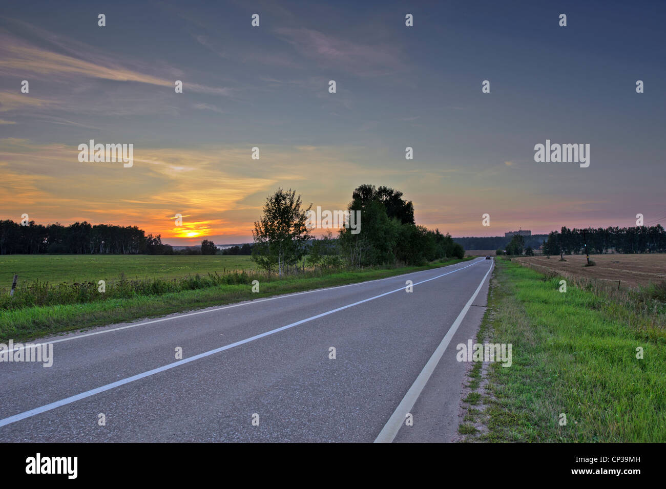 Landscape with asphalt road in sunset light Stock Photo - Alamy