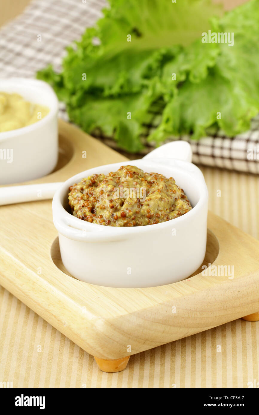 French mustard sauce in white gravy boat Stock Photo