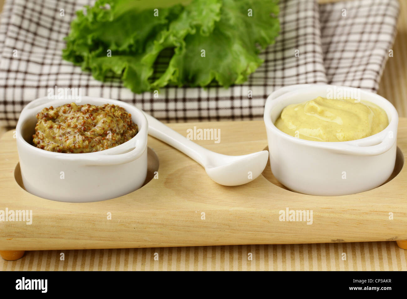 French mustard sauce in white gravy boat Stock Photo