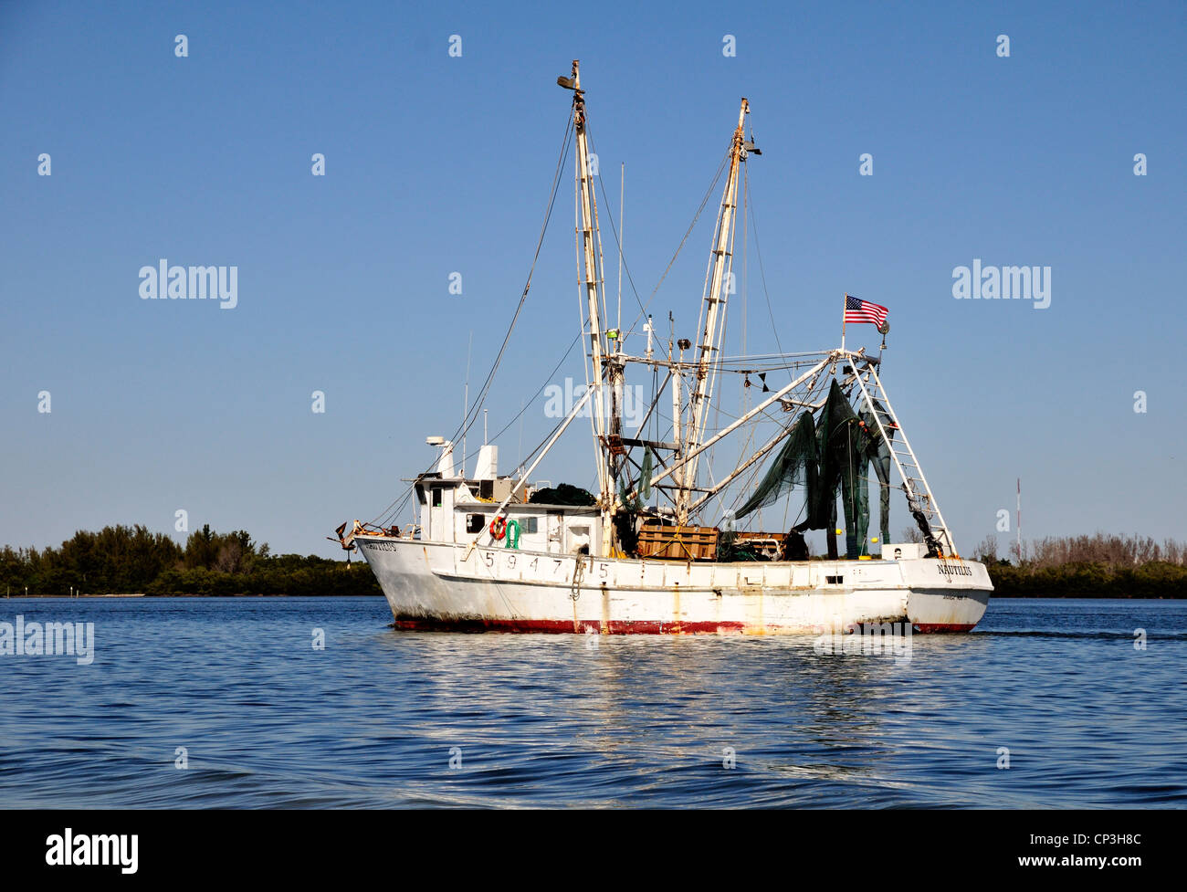 The Nautilus, a commercial fishing vessel, heads out to sea from port in Fort Myers Beach, Florida Stock Photo