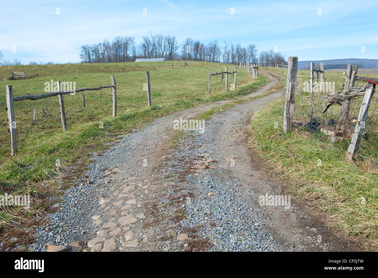 Winding dirt road leads to farm. Stock Photo