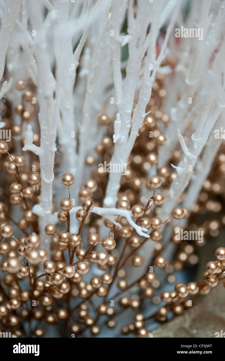 Decorative gold beads stand out against icy branches. Stock Photo